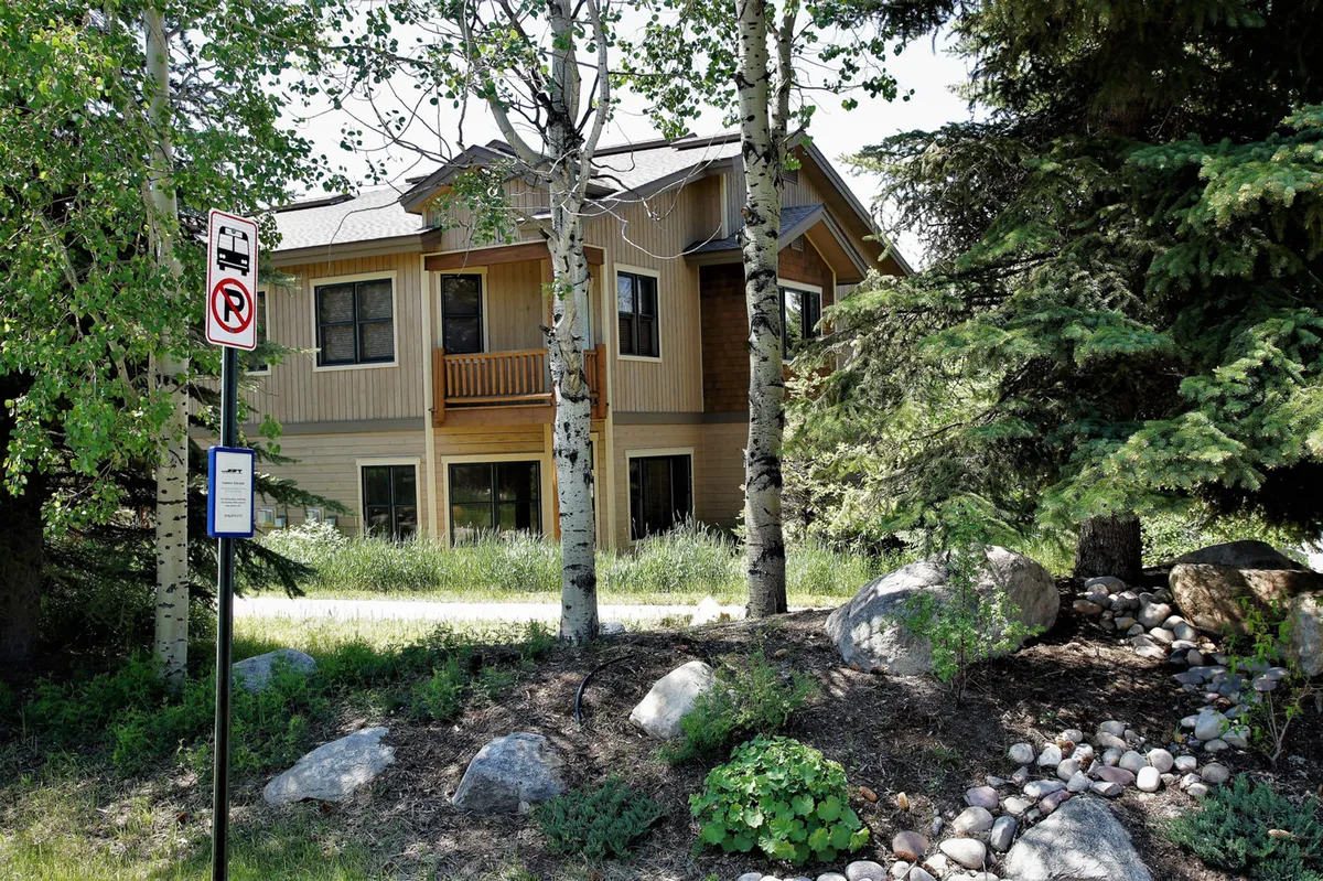 This image presents the exterior of Cornerstone 34, framed by mature trees and thoughtful landscaping. The peaceful outdoor setting is bathed in gentle sunset light, suggesting tranquility and a connection to nature.